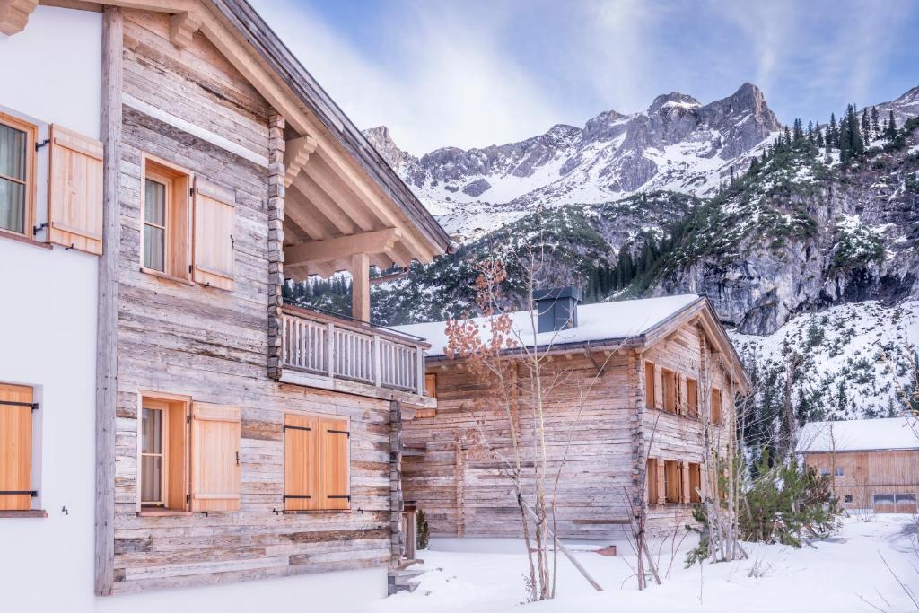 レッヒにあるCircle Chalets Arlbergの山々を背景にした雪の丸太小屋