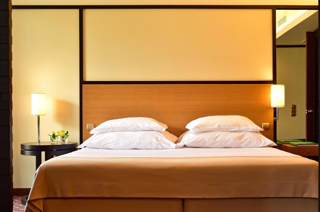 a bedroom with a large bed with two pillows at Pestana Casino Park Hotel & Casino in Funchal