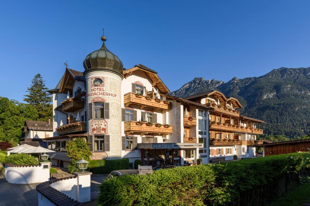 un grand bâtiment avec une tour en haut dans l'établissement Hotel Staudacherhof History & Lifestyle, à Garmisch-Partenkirchen