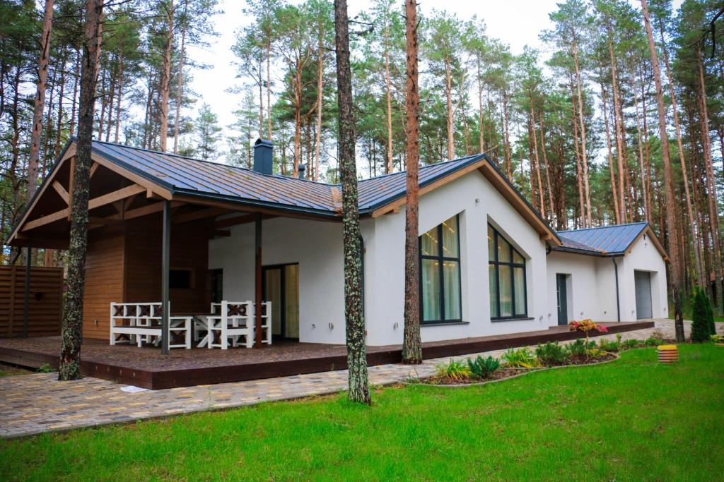 a small house with a porch in the woods at Valsid puhkemaja in Alajõe