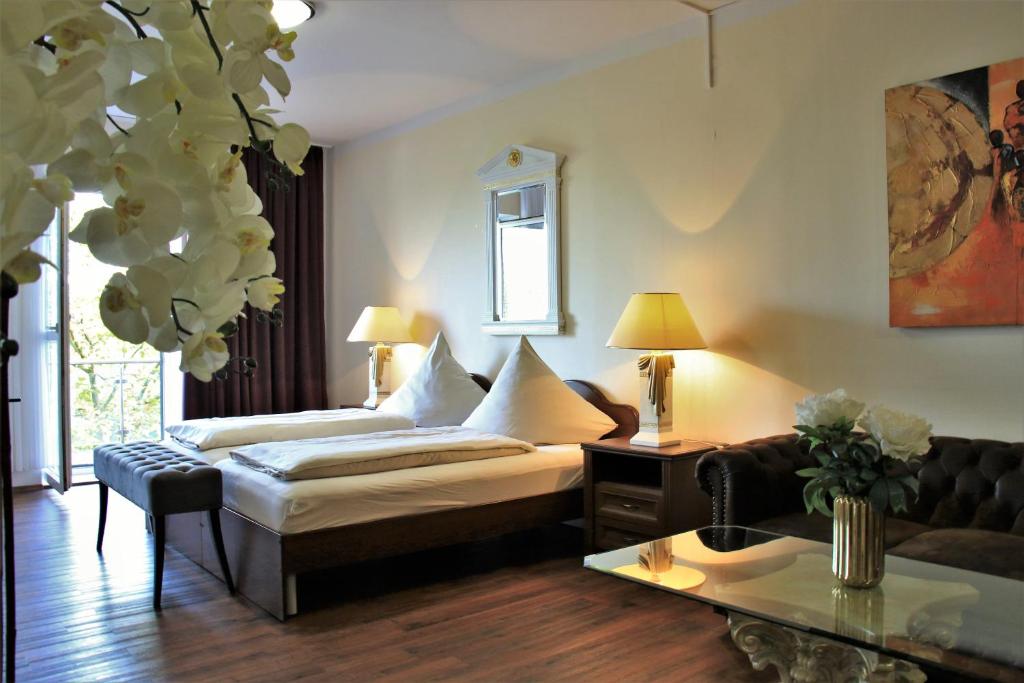 una sala de estar con una cama y un sofá en Aparthotel Scheuer, en Hürth