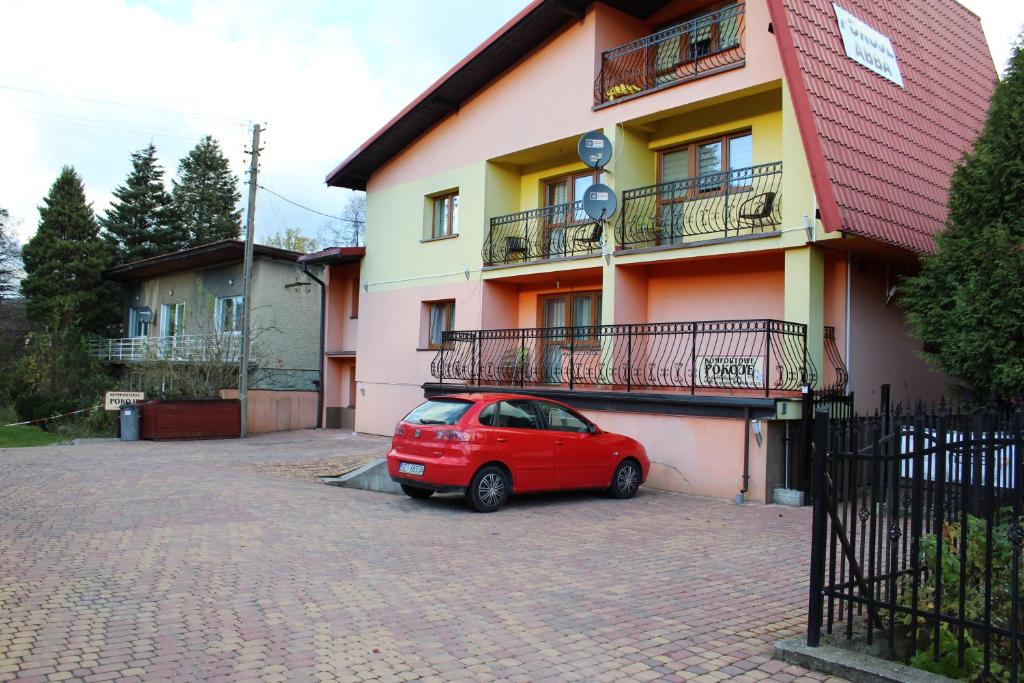 ヴィスワにあるAbba -pokoje wakacyjneの建物前に停車する小型赤車