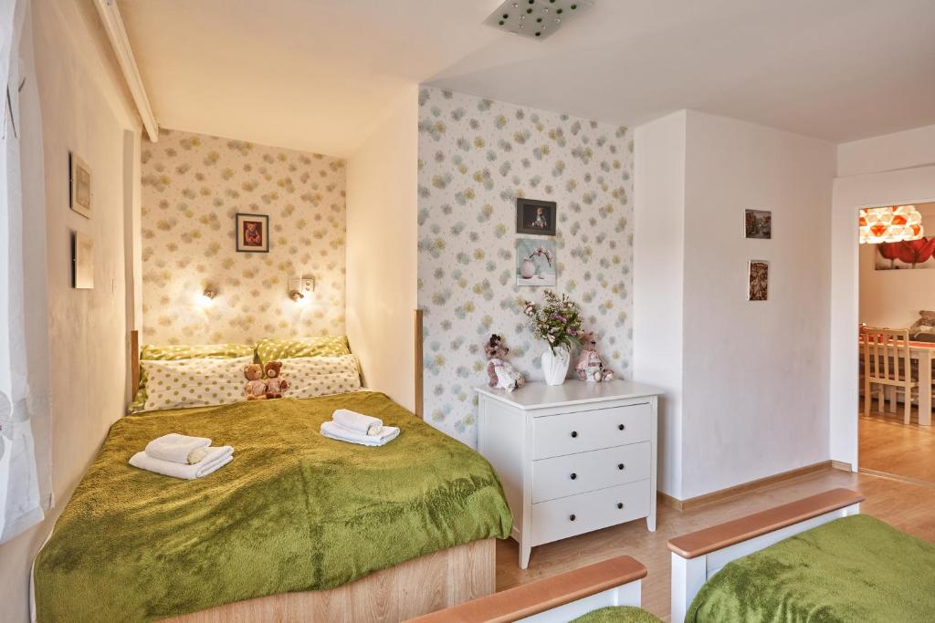 a bedroom with a green bed and a white dresser at Apartment U Medvídka in Karlovy Vary