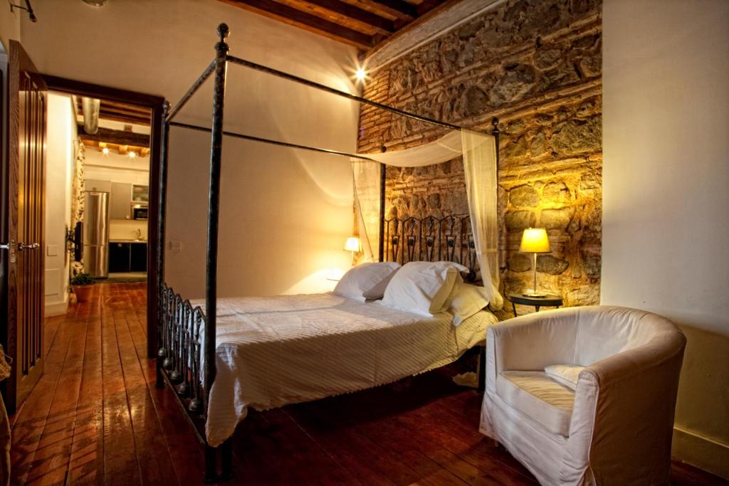 トレドにあるToledo Con Encantoのベッドルーム(天蓋付きベッド1台、椅子付)