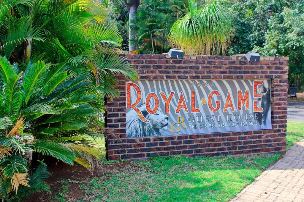um sinal para um jogo de coala numa parede de tijolos em Royal Game Guest House em Phalaborwa