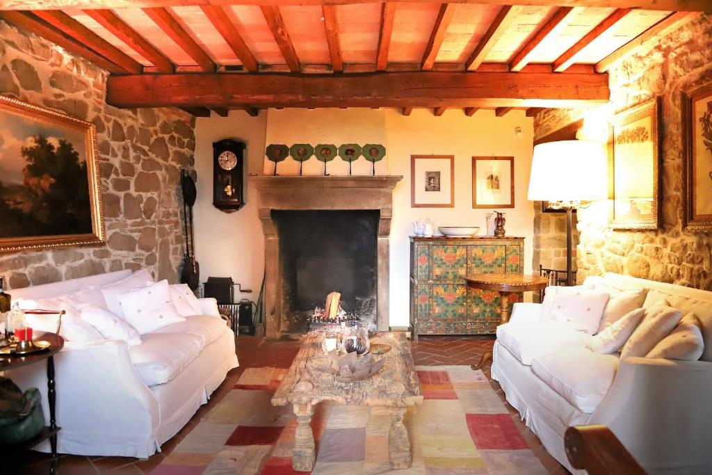sala de estar con sofás blancos y chimenea en Exclusive Tuscany Villa, en Civitella in Val di Chiana