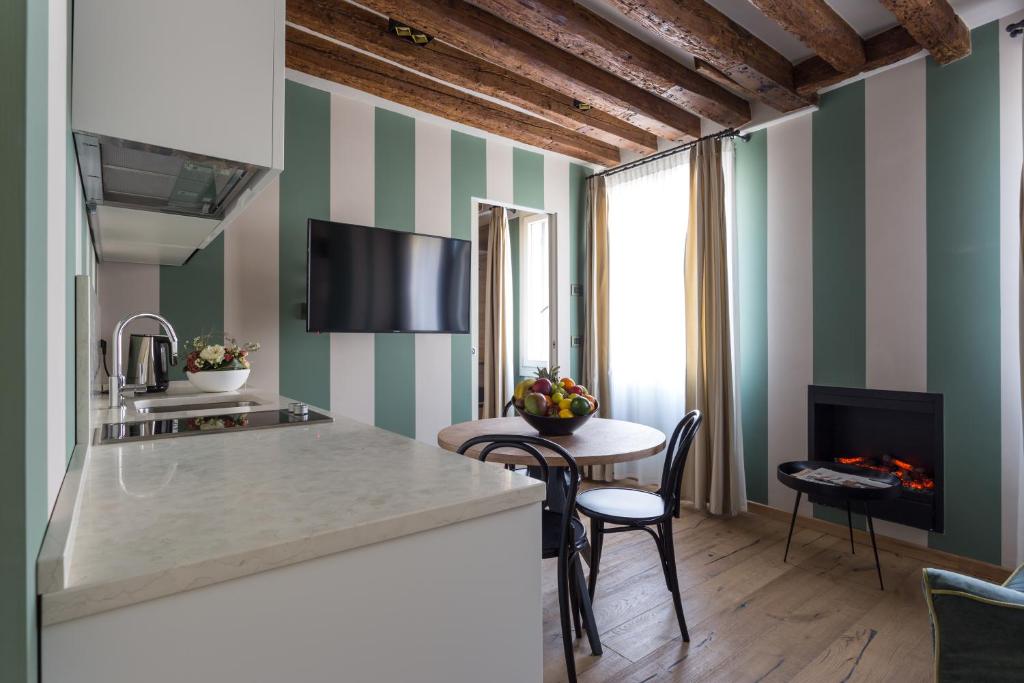 a kitchen with striped walls and a table and chairs at Hotel Tiziano in Venice