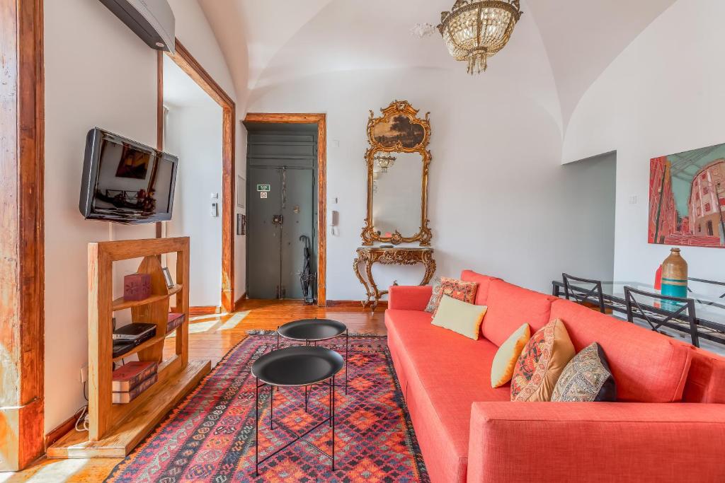 ein Wohnzimmer mit einem roten Sofa und einem TV in der Unterkunft Lisbon Downtown Apartment Figueira in Lissabon