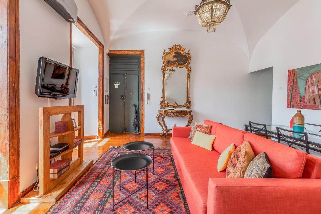 a living room with a red couch and a tv at Lisbon Downtown Apartment Figueira in Lisbon