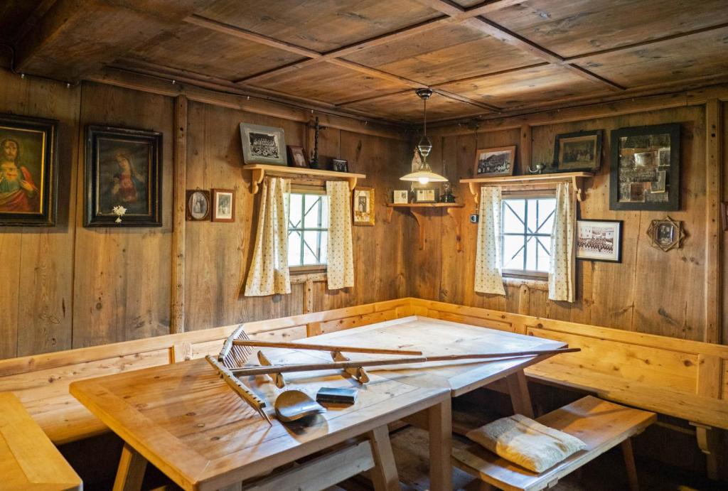 Holzzimmer mit einem Tisch und Fenstern in der Unterkunft Landgasthof Steiner in Matrei in Osttirol