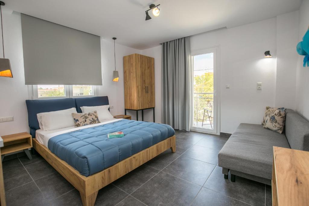 a bedroom with a blue bed and a couch at Linden Apartments in Potos