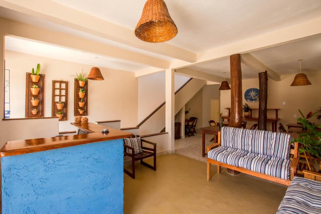 a living room with a couch and a bar at Pousada Ilha do Encanto in Ilha de Boipeba