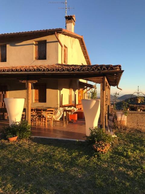 a house with a deck with a table and chairs at Ca' Amorino in Galzignano