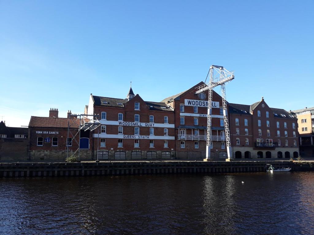 a building with a sign on the side of a river at Riverside Apartment York in York