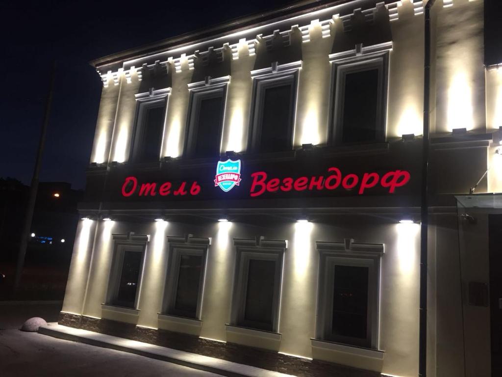 モスクワにあるWesendorf Tagankaの夜間の看板のある建物