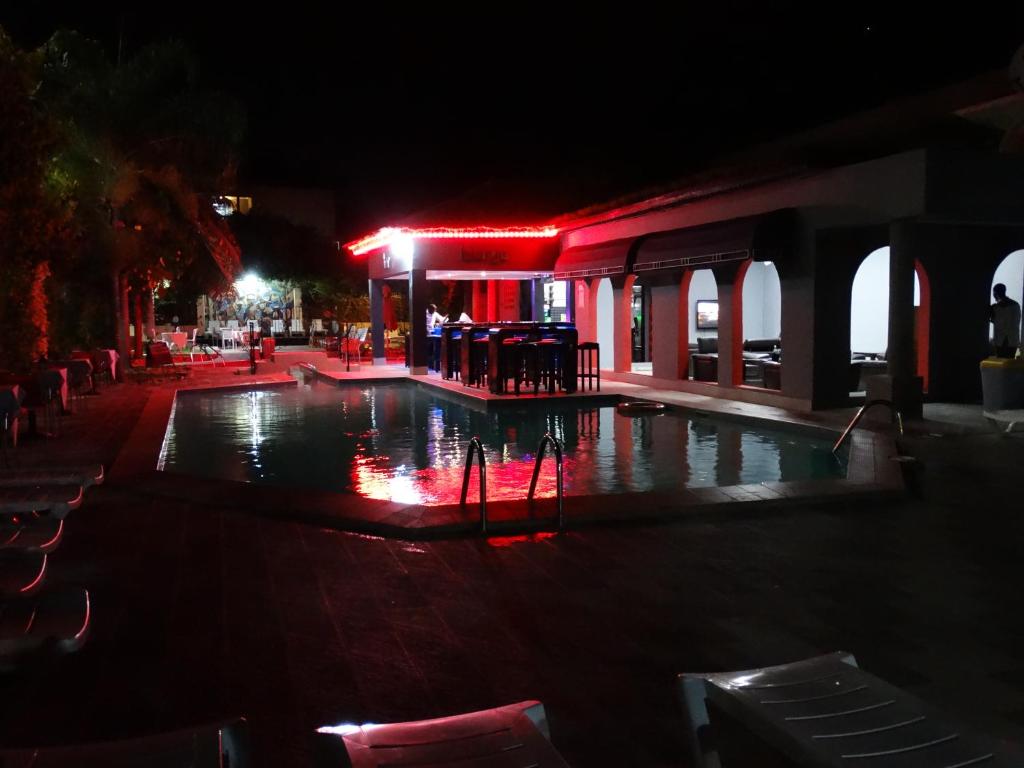 una piscina vacía por la noche con luces rojas en Seaview Gardens Hotel en Kololi