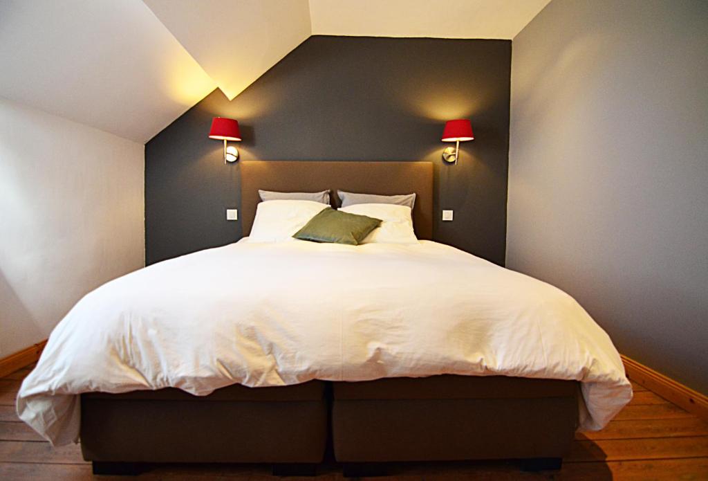ヌシャトーにあるLa Citadine-Gîte citadinのベッドルーム(白い大型ベッド、ランプ2つ付)