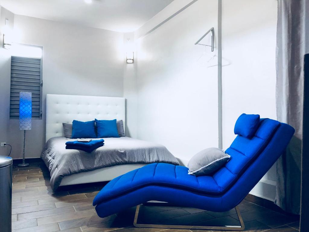 a bedroom with a blue couch next to a bed at Modern Suite #0 - best location in Aguadilla