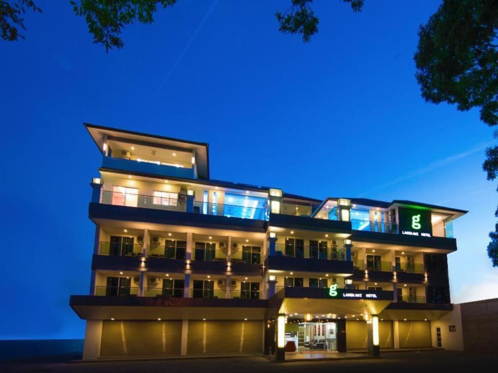un grand bâtiment avec des lumières allumées la nuit dans l'établissement G Langkawi Motel, à Kuah