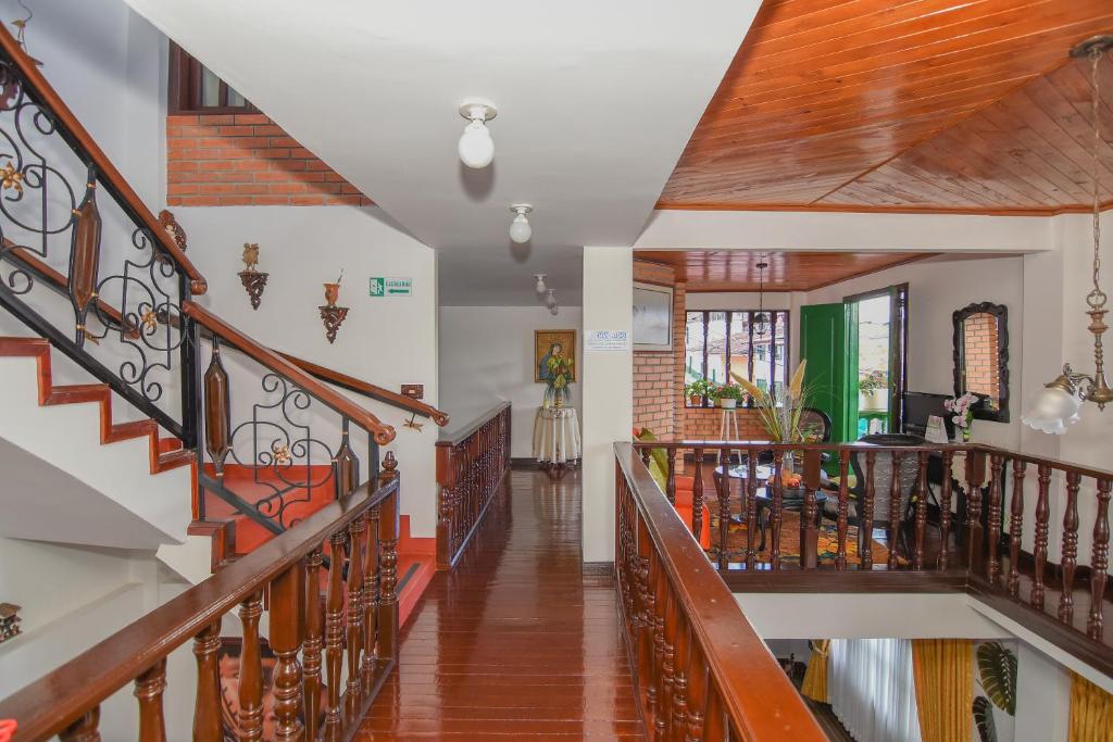 un pasillo de una casa con barandillas de madera en HOTEL LA CASONA SAN AGUSTIn en San Agustín
