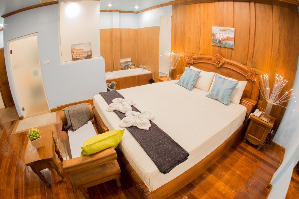 A wood-panelled bedroom with a carved double bed and a small sitting area.