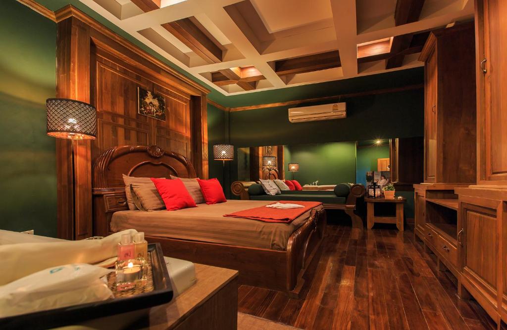 A richly furnished double bedroom with a carved wooden bed, sofa and large wardrobe.