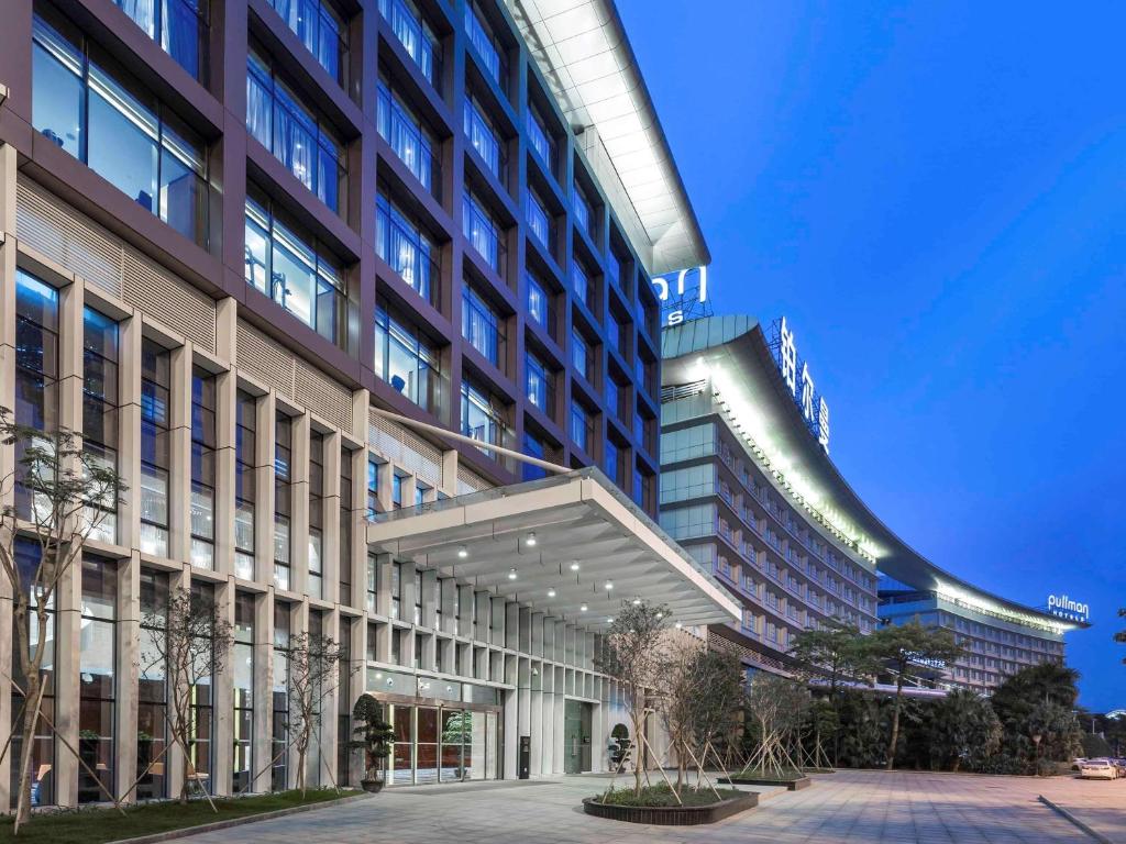 a large building with a lit up facade at Pullman Guangzhou Baiyun Airport in Guangzhou