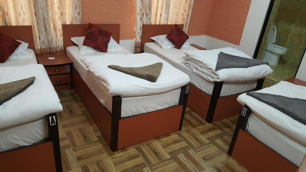 a group of three beds in a room at BnB Royal Tourist House in Kathmandu