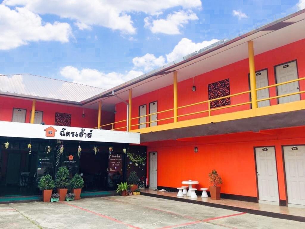 ein rotes Gebäude mit Balkon in der Unterkunft Chat House Soi 18 Mithuna Chiangrai in Chiang Rai