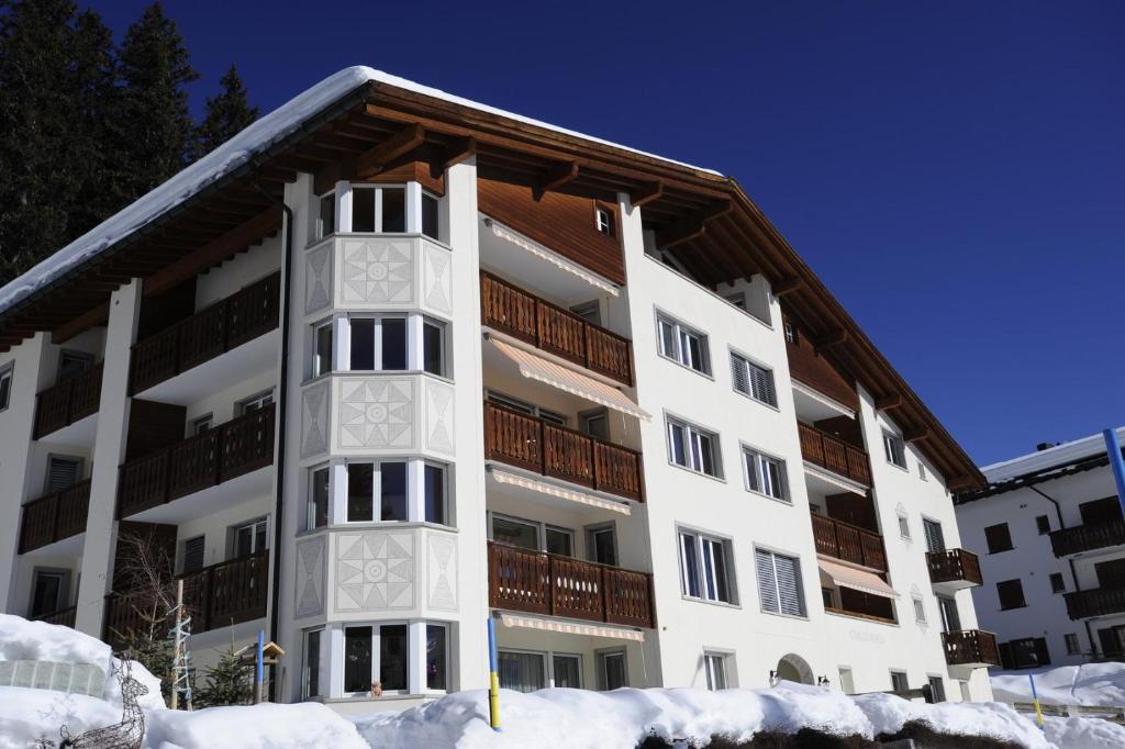 an apartment building with snow in front of it at Chalchboda 1 in Arosa
