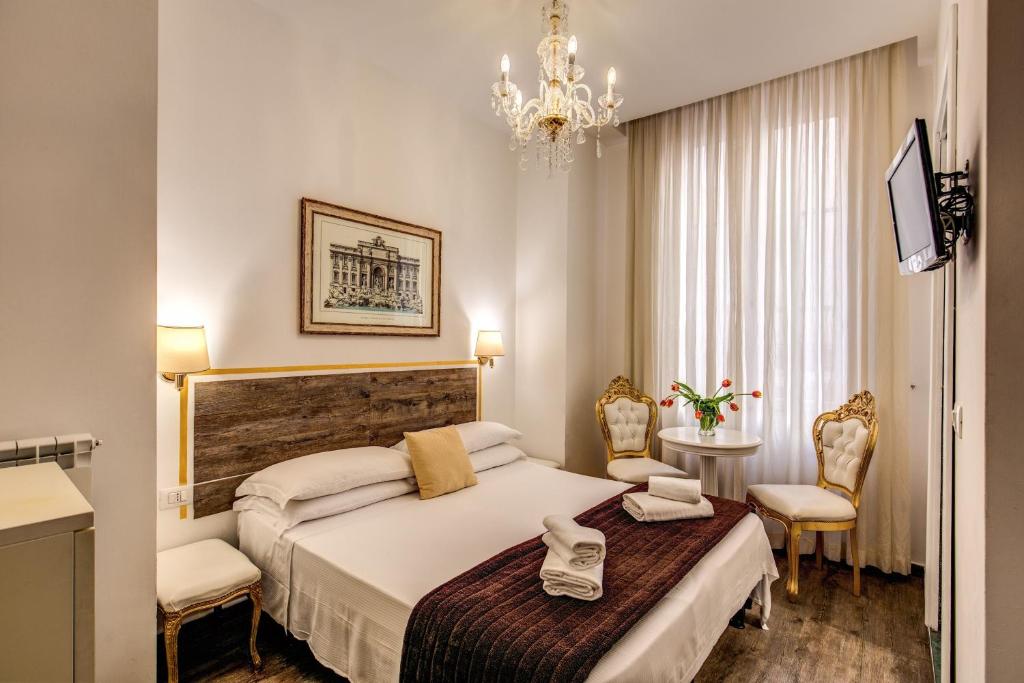 a hotel room with a bed and a chandelier at Ripetta 226 in Rome