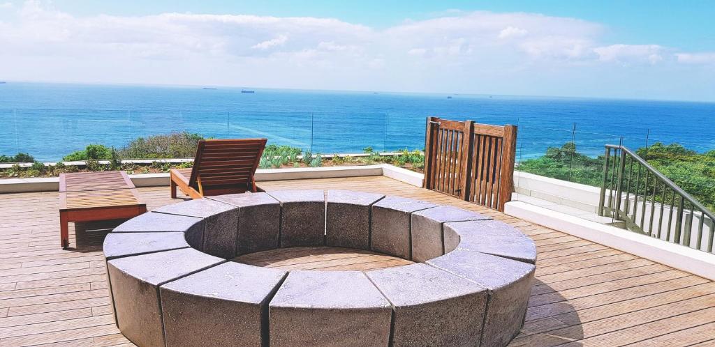 a fire pit on a deck with a view of the ocean at Ocean Dune Studio in Sibaya