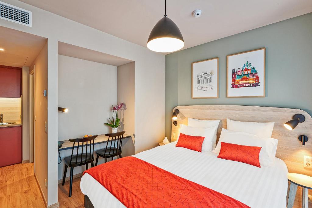 1 dormitorio con 1 cama y 1 mesa con sillas en Appart'City Confort Bruxelles Centre Gare du Midi en Bruselas