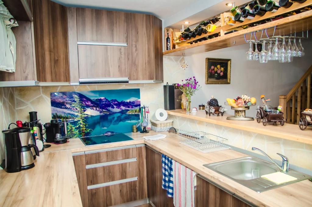 eine Küche mit Holzschränken und einer Spüle in der Unterkunft Casa Csiki in Râșnov