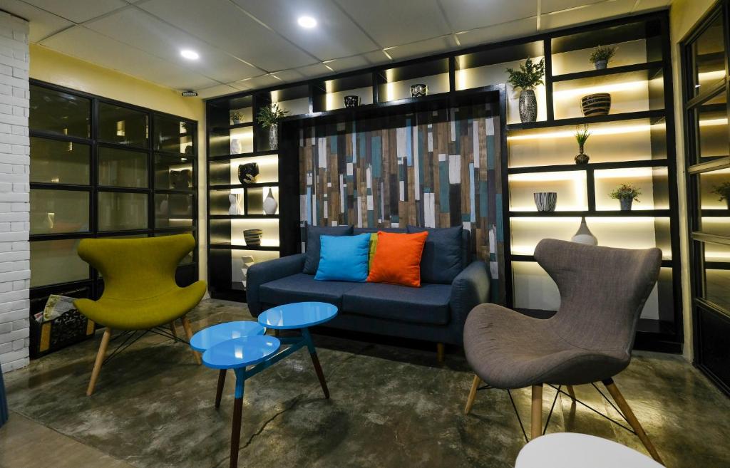 達古潘的住宿－瓦勒斯塔賓館，客厅配有两把椅子和蓝色沙发