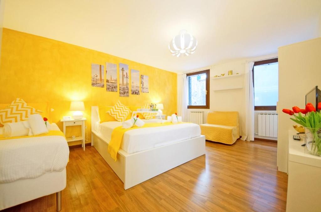 ein Schlafzimmer mit 2 Betten und einer gelben Wand in der Unterkunft San Marco Apartment Fabbri in Venedig