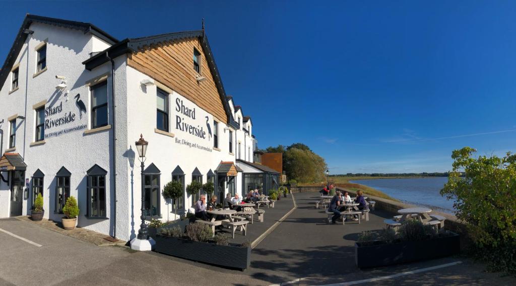 people sitting outside of a building next to the water at Shard Riverside in Poulton le Fylde