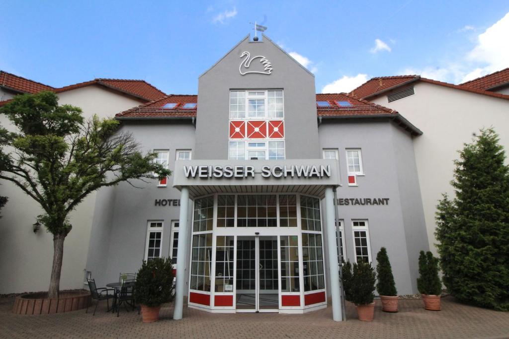 a white building with a sign that reads westchester southern at Hotel Weisser Schwan in Erfurt