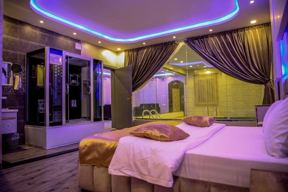 a bedroom with a large bed with a purple ceiling at Kinda Resort Luxury Villas in Taif