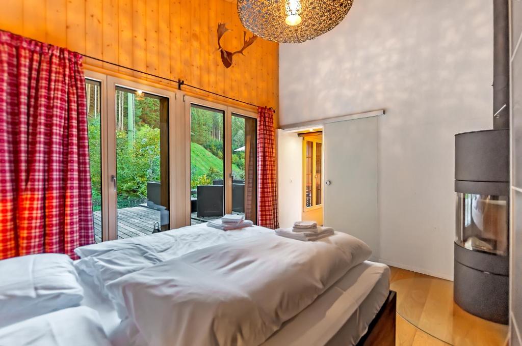 een slaapkamer met een bed en een groot raam bij Charming Little Chalet for 6 People & Free Ski Lockers in Grindelwald