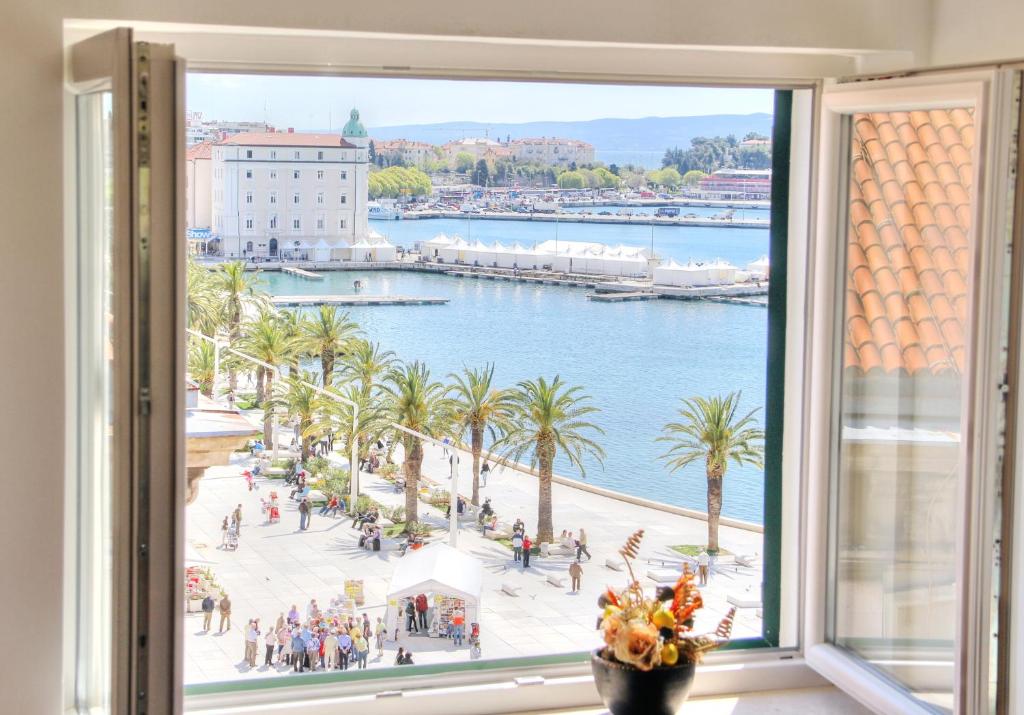 een raam met uitzicht op een haven bij Apartments & Rooms Grašo in Split