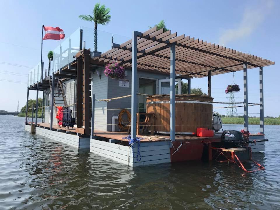 ein Haus auf einem schwimmenden Dock im Wasser in der Unterkunft Houseboat on the water in Liepāja