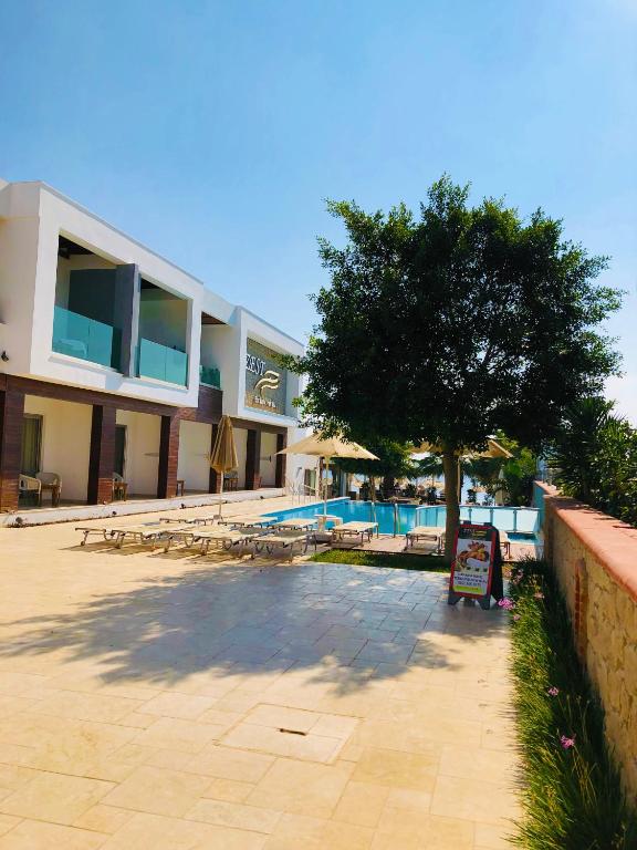 a building with a tree and a swimming pool at Zest Exclusive Hotel & Spa in Ortakent