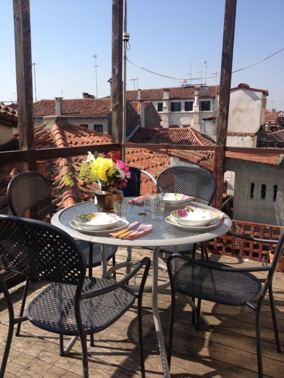 einen Tisch und Stühle auf einem Balkon mit Stadtblick in der Unterkunft TINTORETTO 1 CON TERRAZZA SOPRA IL TETTO, 3 bagni, 3 grandi camere da letto, SUPER NUOVO in Venedig