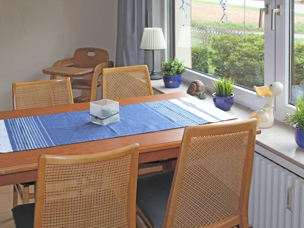 stół jadalny z krzesłami i niebieską tkaniną w obiekcie Beautiful apartment in Bodenwerder with balcony w mieście Bodenwerder