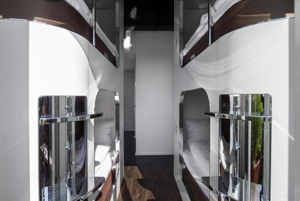 a room with two bunk beds and two mirrors at Steel House Copenhagen in Copenhagen