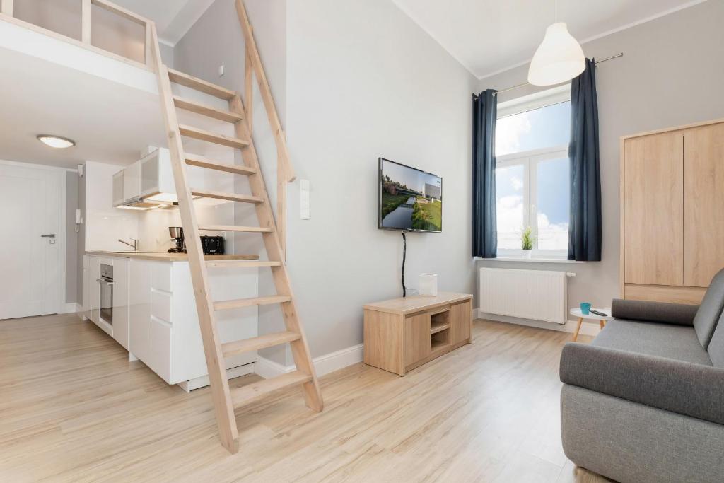 - un salon avec un escalier et un canapé dans l'établissement Apartments Poznań MTP by Renters, à Poznań