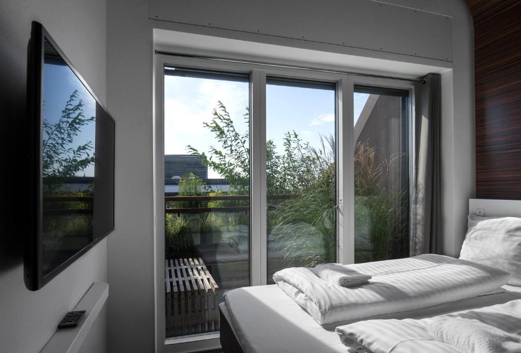 a room with a window with a bed and a view at Steel House Copenhagen in Copenhagen