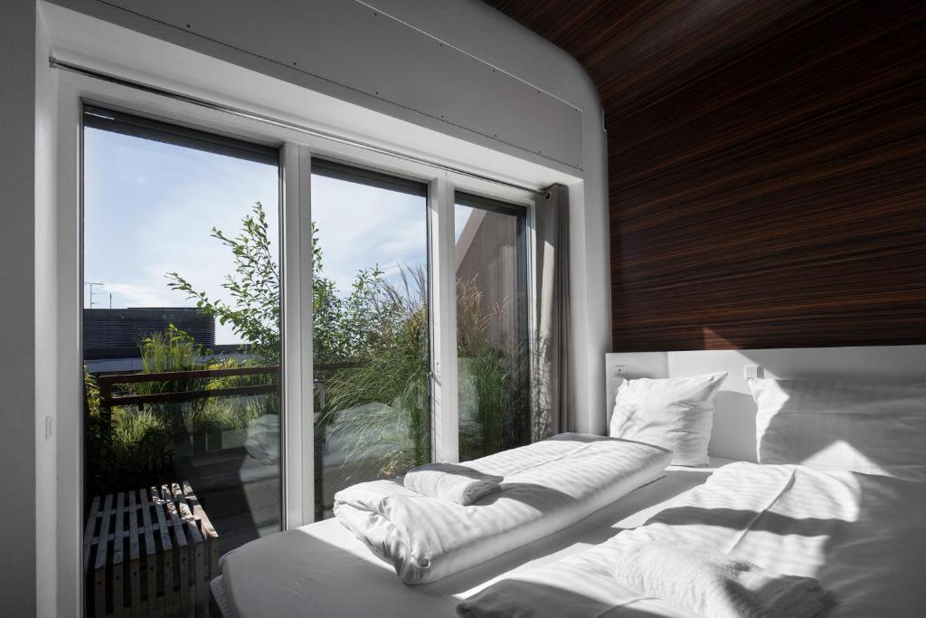 a bedroom with two beds and a large window at Steel House Copenhagen in Copenhagen