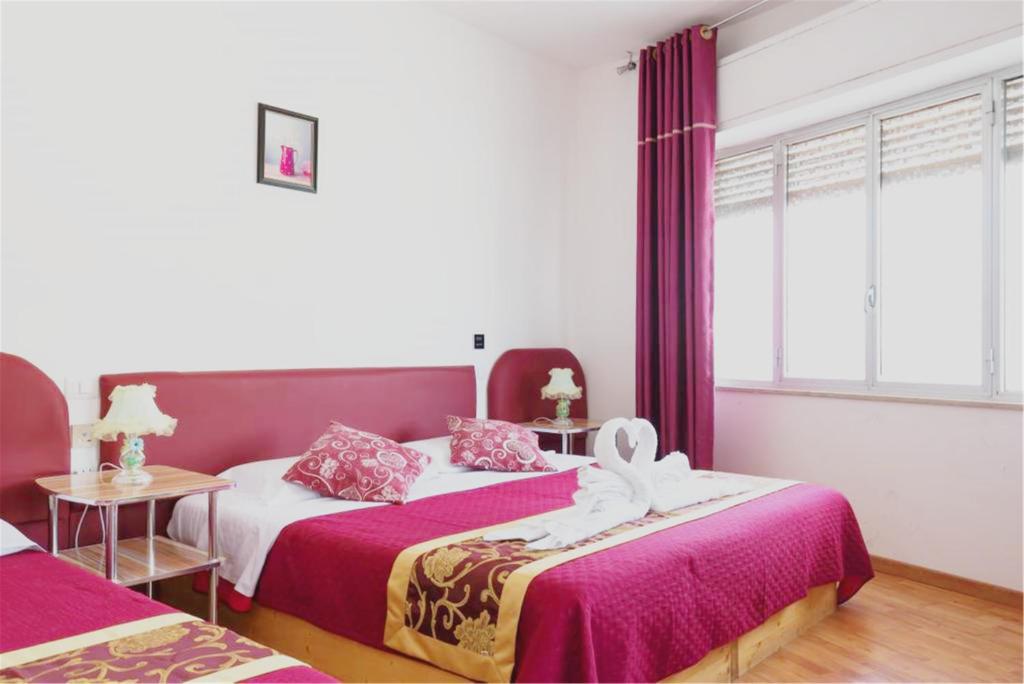 una camera con due letti con lenzuola rosse e bianche di B&B Ciclamino a Siracusa